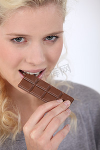 味美价廉摄影照片_女人咬一块巧克力
