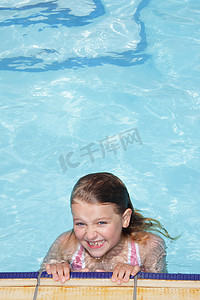 孩子游泳摄影照片_游泳池里微笑的女孩