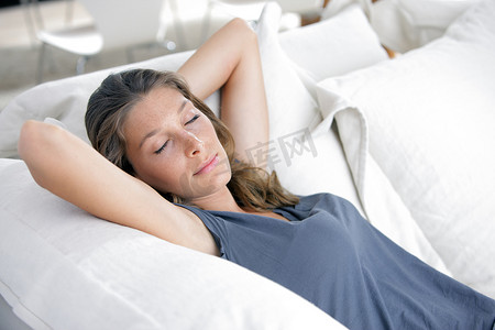 女人睡觉摄影照片_睡在白色沙发上的年轻漂亮女人