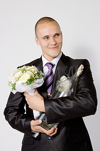 年轻人，未婚夫，带着花束和一瓶伏特加