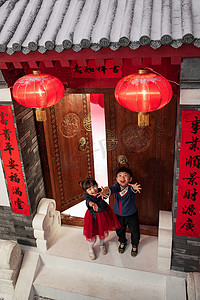 红色新春活动摄影照片_雪中快乐的男孩女孩庆祝新春