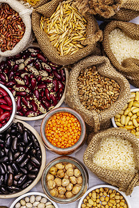 不可伪造摄影照片_对不同类型的豆类和谷类谷物进行分类。一组健康生活所不可缺少的蛋白质来源。白色木板背景
