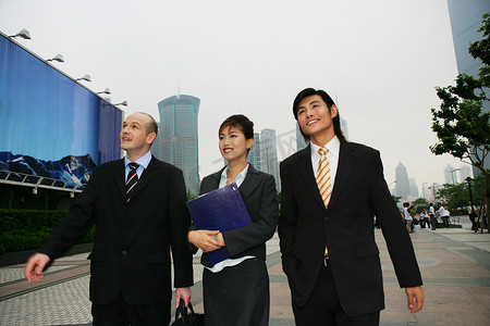 上海浦东街头三位中外商务人士行走交谈