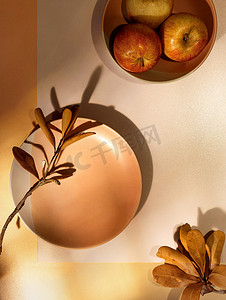 秋天扁平摄影照片_秋天的扁平铺满了盘子、干叶和苹果