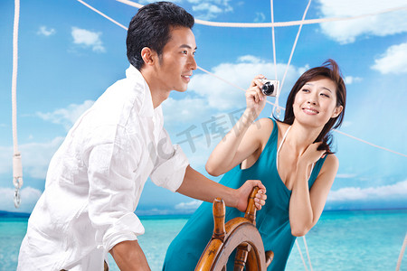 彩色船舵摄影照片_东方情侣海滩休闲生活