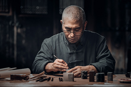 在工作室里认真雕刻印章的专家