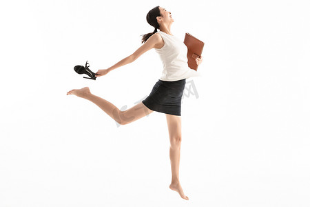 女人拿着笔记本摄影照片_兴奋跳跃的商务女青年