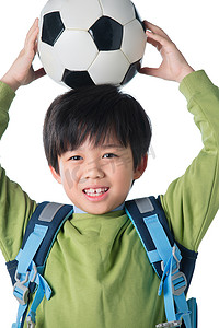 小学体育锻炼摄影照片_一个男孩把足球放在头顶