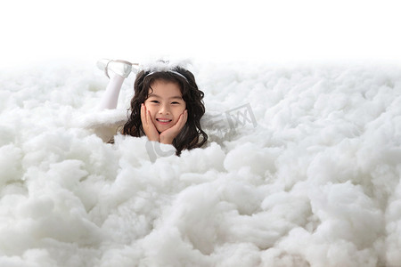 儿童云朵背景摄影照片_趴在云朵里的快乐小天使
