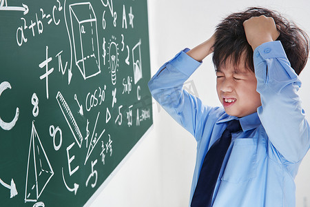 忧虑的摄影照片_小学男生被数学题难住