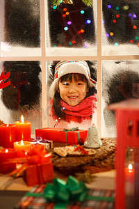 小女孩透过窗户看圣诞节礼物