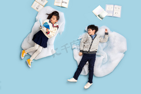 快乐儿童躺在云彩上看书