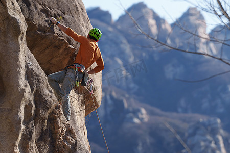 风险图片摄影照片_青年男人在悬崖峭壁上攀岩