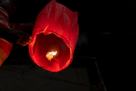 小孔明灯摄影照片_天空灯笼或孔明灯笼或中国灯笼，是用纸制成的小热气球，底部有一个小火悬浮的开口。夜空蜡烛或火球.