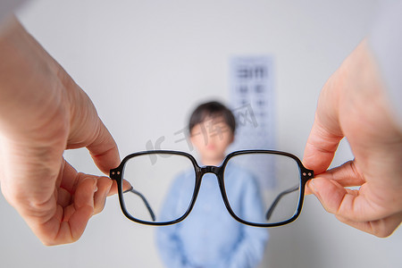 视力检测图片摄影照片_需要佩戴眼镜的小学男生