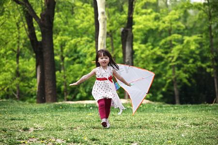 风筝玩具摄影照片_一个小女孩在户外放风筝