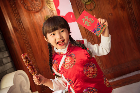 中国新年红包摄影照片_手拿糖葫芦红包的快乐小女孩