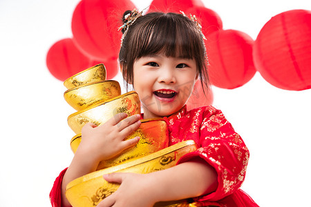 新年灯笼金色摄影照片_可爱的小女孩抱着金元宝