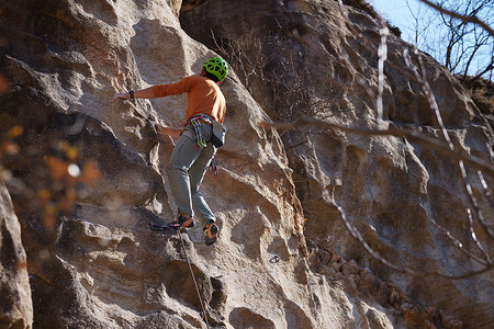 极限攀岩摄影照片_青年男人在悬崖峭壁上攀岩