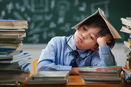 儿童正面摄影照片_面对作业苦恼的小学生