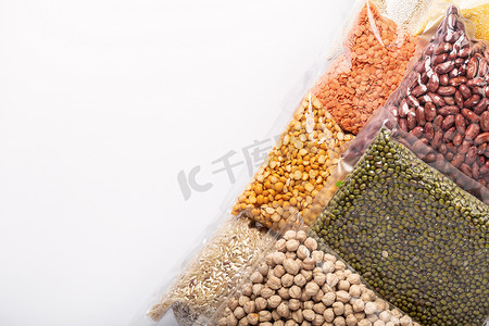 白色背景，有彩色背景的食物供应。一组五颜六色的谷物和豆科植物用塑料包裹着.蛋白质产品