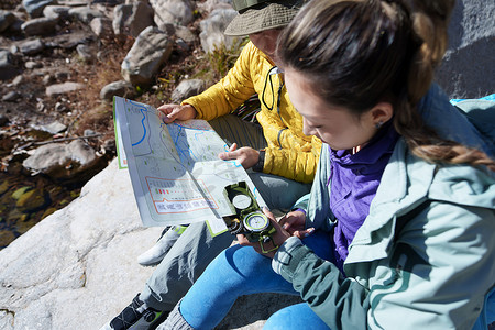 讨论地图摄影照片_户外旅游的青年伴侣使用地图指南针