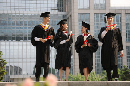 留学生毕业生摄影照片_四个身穿学士服的大学生