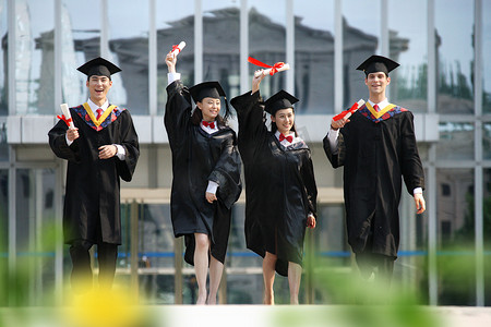 校园留学摄影照片_四个身穿学士服的大学生