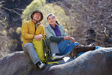 徒步旅行的青年伴侣坐在石头上休息