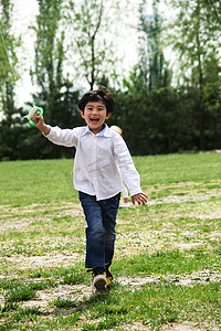 风筝玩具摄影照片_一个小男孩在户外放风筝