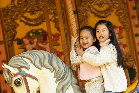 两个小女孩在玩旋转木马