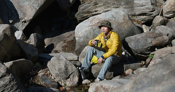 徒步旅行的青年男人坐在石头上休息