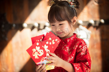 中国新年红包摄影照片_可爱的小女孩拿着红包