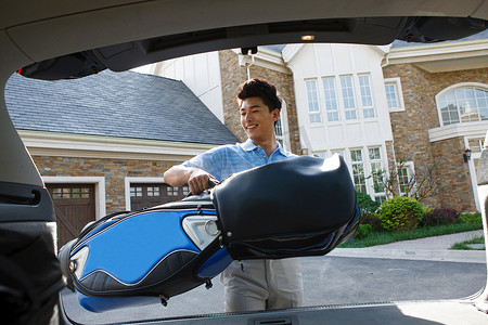 一个青年男人背着高尔夫球包