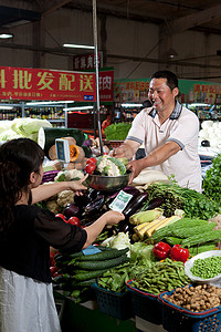 一个菜农在菜市场里卖菜