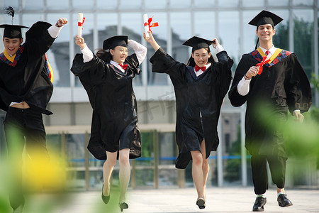 毕业学士服摄影照片_四个身穿学士服的大学生