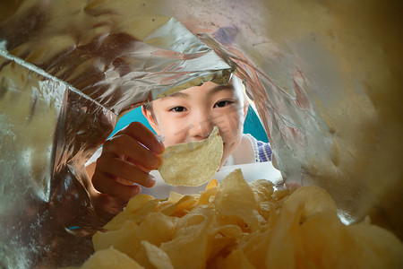 彩色油炸食品摄影照片_吃薯片的小女孩