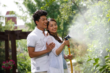 花朵植物盆栽摄影照片_东方夫妇户外浇花