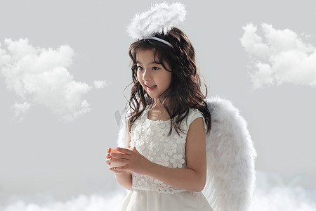 天使侧面翅膀摄影照片_拿着蜡烛的可爱小天使