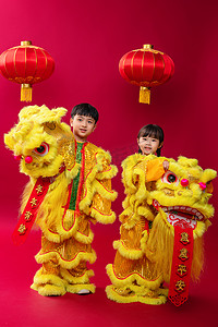 舞狮的女孩摄影照片_欢乐的男孩女孩舞狮庆祝新年