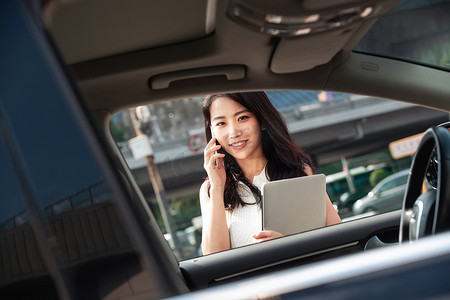 打电话的青年女人走向汽车