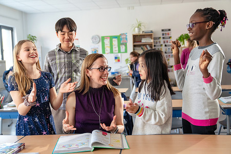 教师辅导小学生在教室里学习