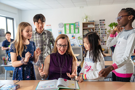 教师辅导小学生在教室里学习