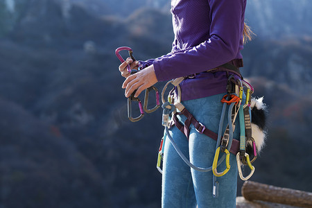 青年女性登山者调整安全设备