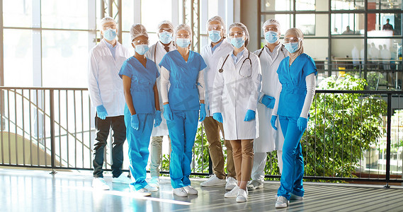 由医院的专业男医生和女医生组成的混合种族小组。室内。国际医学界戴口罩的一群医生.身穿长袍、身穿制服的多族裔医生诊所.
