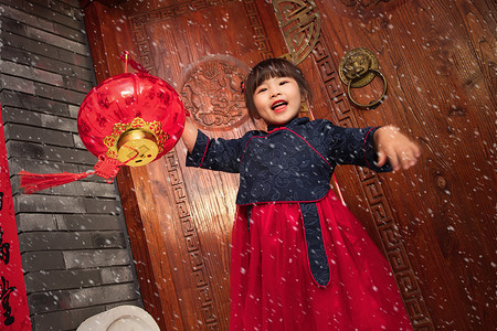 雪中的小女孩手提红灯笼庆祝新年