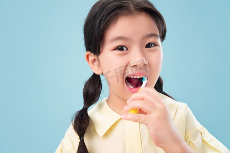 积极树消极树摄影照片_拿着牙刷刷牙的小女孩