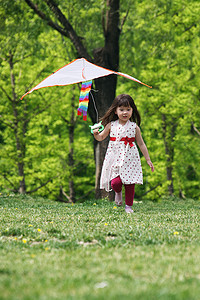 风筝玩具摄影照片_一个小女孩在户外玩耍