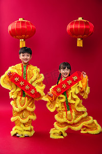 新年背景舞狮摄影照片_欢乐的男孩女孩舞狮庆祝新年