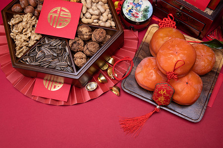 新年吉祥金色摄影照片_柿子和中式坚果果盘